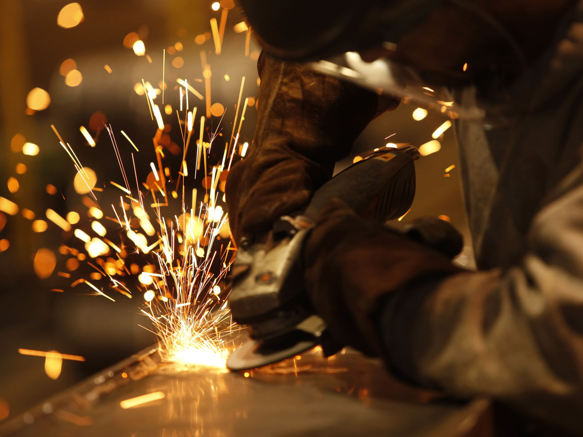 A trades person welding and sparks flying